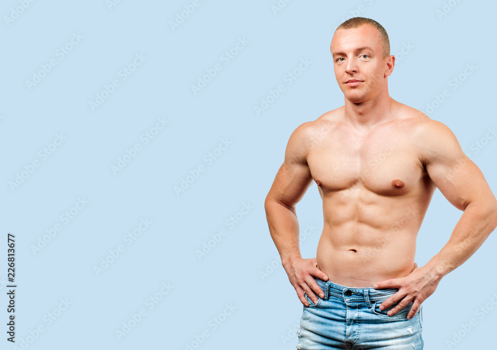 Fitness muscular man showing six pack on blue background