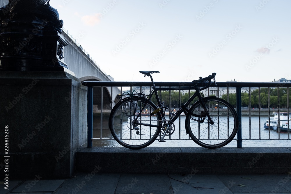 Bicycle tied to a railing by the Thames river