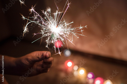 Bright festive Christmas sparkler in hand toning. Happy new year. Christmas celebration lights.