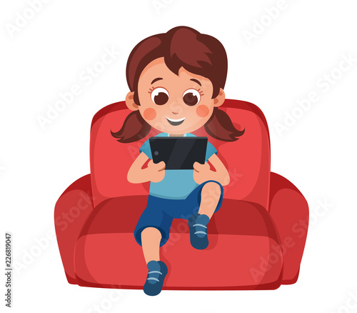 Little girl uses a smartphone sitting on couch.  Tablet computer. technology and children. Social networks for kids