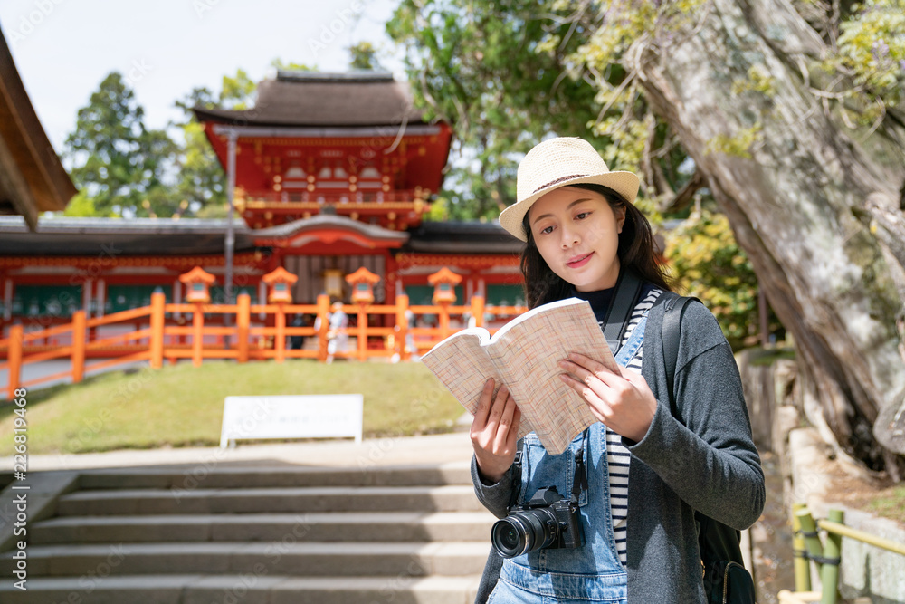tourist reading information on her guidebook