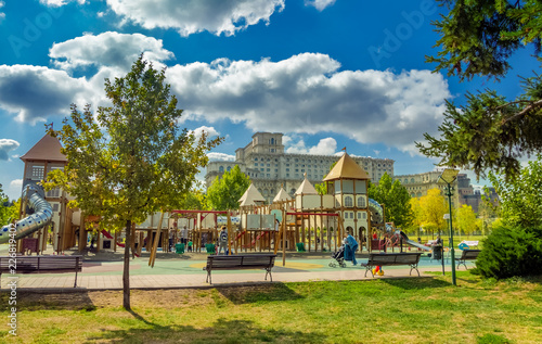 Playgroud for Kids in Izvor park and famous Parliament building landmark in Bucharest, Romania photo