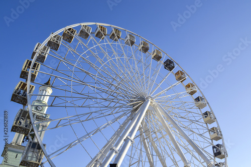 Ferris wheel against a blue sky background.