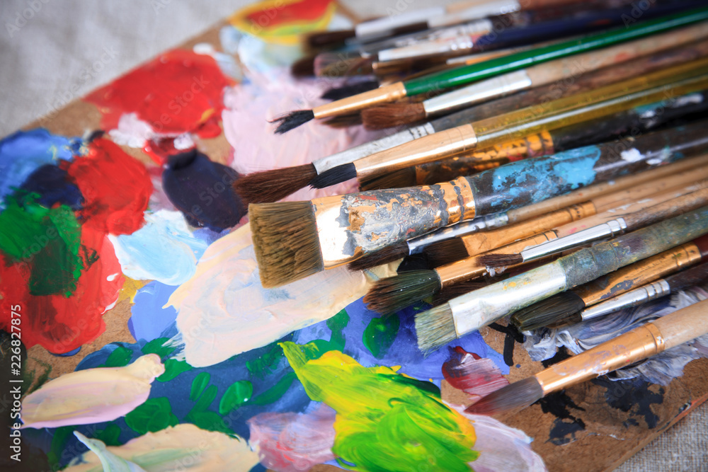 Fototapeta premium Multicolored palette and many different brushes.