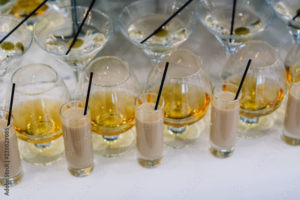 A row of martini and brandy glasses on bar. Celebration or other event. A row of martini and brandy glasses on bar. Celebration or other event.