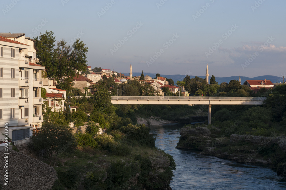 Bosnia: lo skyline di Mostar, la città che prende il nome dai guardiani del ponte (mostari) che nel medioevo custodivano lo Stari Most (Ponte Vecchio), visto dalle acque verdi del fiume Narenta