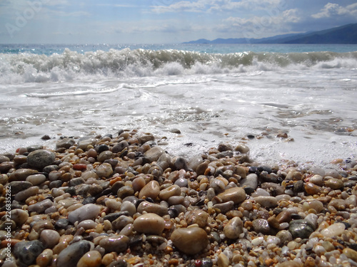 Gravel beach with stormy sea waves