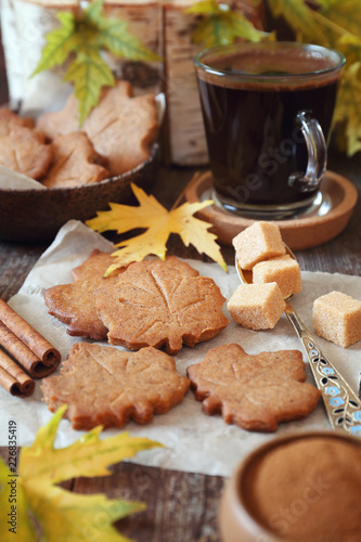 Autumn coffee break: cinnamon cookies in form of maple leaves, coffee and yellow leaves