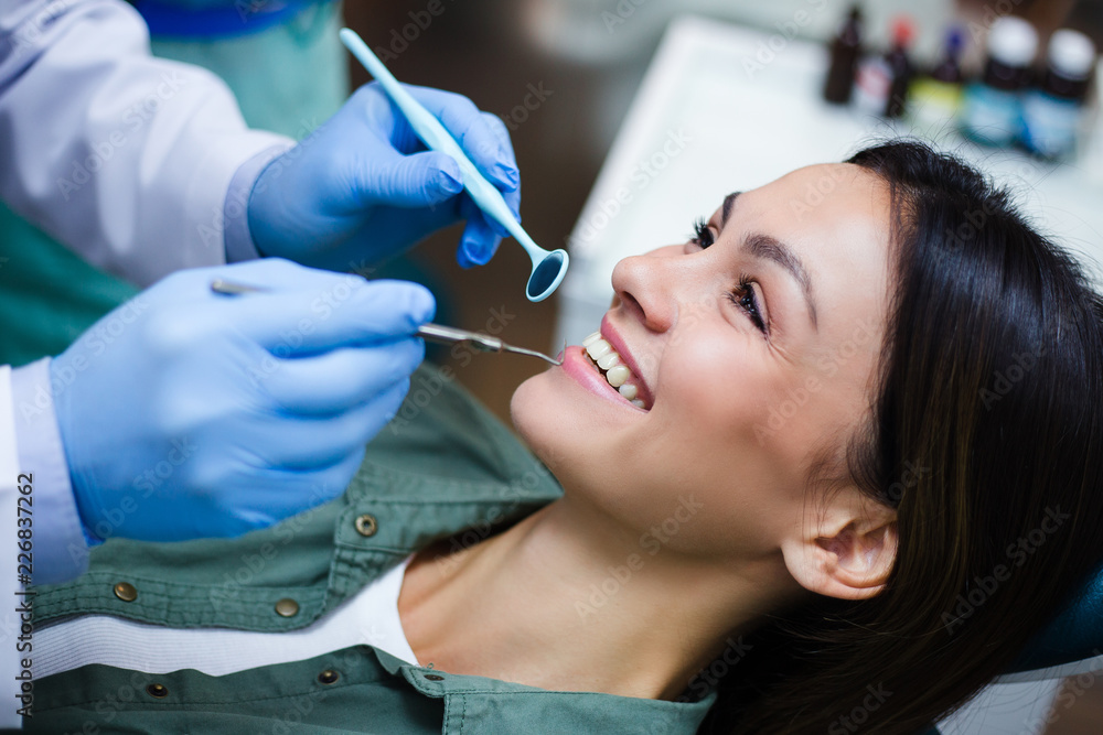 Her stunning smile! Close-up of dentist examining his beautiful patient in dentist’s office Her stunning smile! Close-up of dentist examining his beautiful patient in dentist’s office