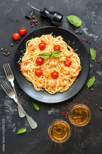 Spaghetti pasta with shrimps and white wine on a dark stone background. Top view