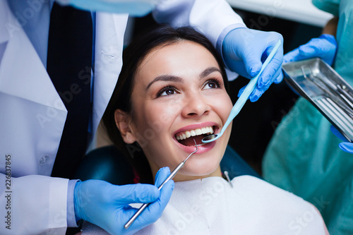 Perfect smile! Part of dentist examining his beautiful patient in dentist’s office