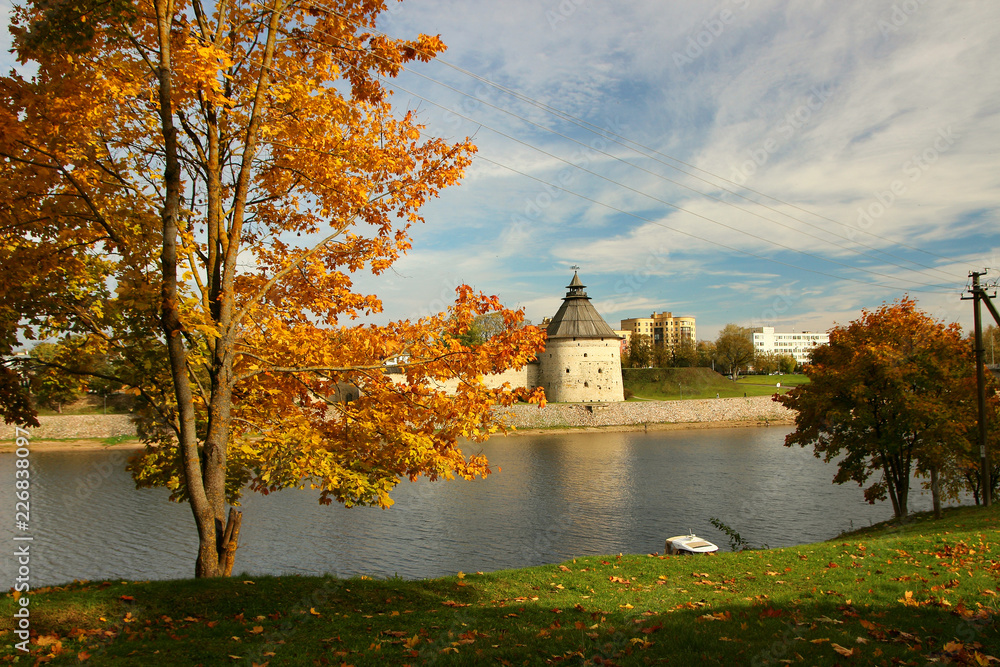 Fototapeta premium Beautiful autumn day in the park of the city of Pskov with a view of the tower..