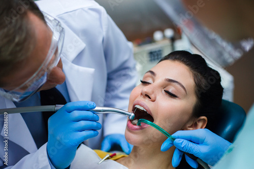 We have a little hole here. Close-up of dentist examining his beautiful patient in dentist   s office