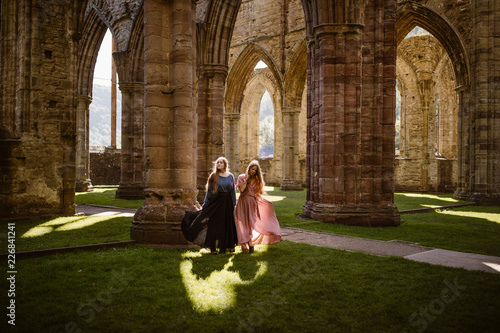 tow women in long dresses in an old abandoned welsh trintern celtic abby photo