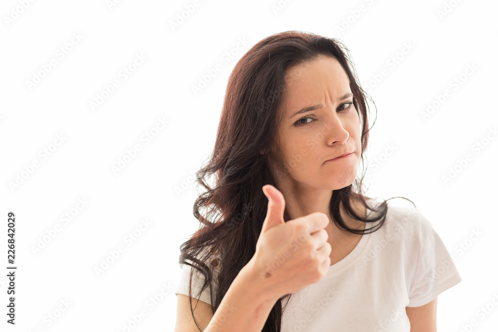Caucasian girl with long dark hair expresses emotions of approval having raised a hand thumb up. The girl in light clothes on a white background. The place for an inscription or the text. Horizontal Caucasian girl with long dark hair expresses emotions of approval having raised a hand thumb up. The girl in light clothes on a white background. The place for an inscription or the text. Horizontal