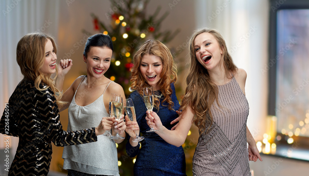 celebration, party and holidays concept - happy women clinking champagne glasses and dancing over room and christmas tree lights background