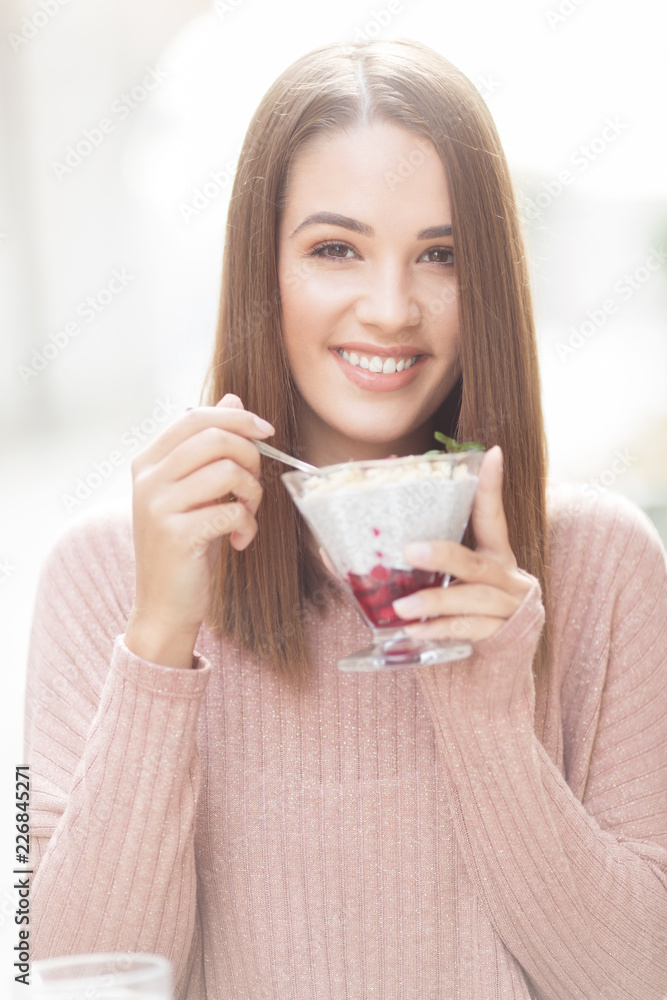 Young beautiful woman sitting in a cafe outdoors,eating salad and smiling Young beautiful woman sitting in a cafe outdoors,eating salad and smiling