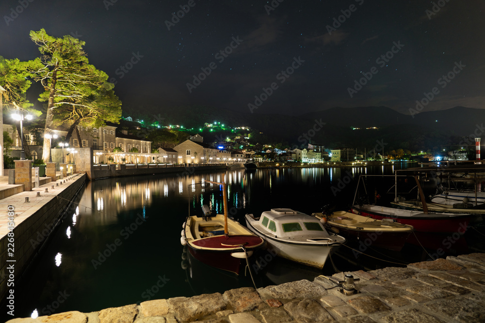 Fishing boats at the waterfront at night. Coastal town.