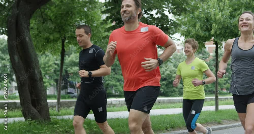 Group of men and women running in city park