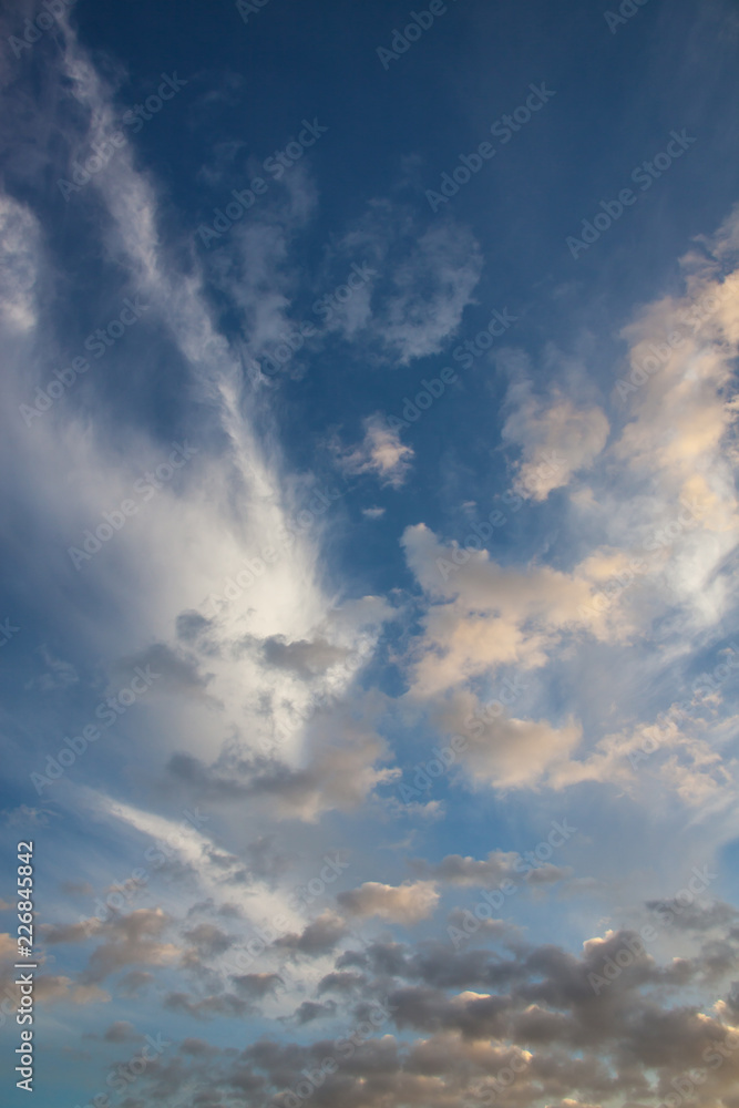 Fototapeta premium Blue sky background with picturesque lit clouds