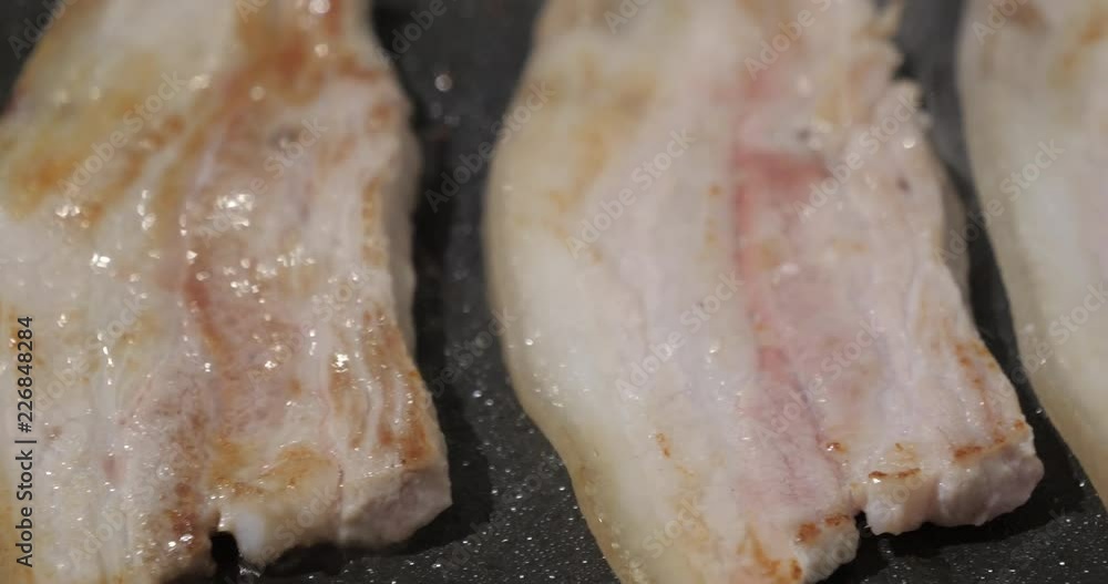 Pork slices being grilled on a non-stick coating teppanyaki plate. Closeup view Pork slices being grilled on a non-stick coating teppanyaki plate. Closeup view