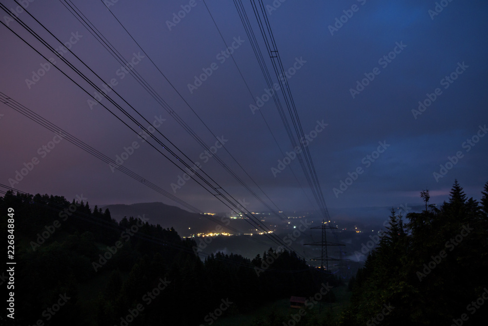 Strommasten zur blauen Stunde über dem Tal