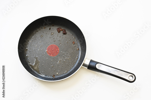 Dirty frying pan on a white background.