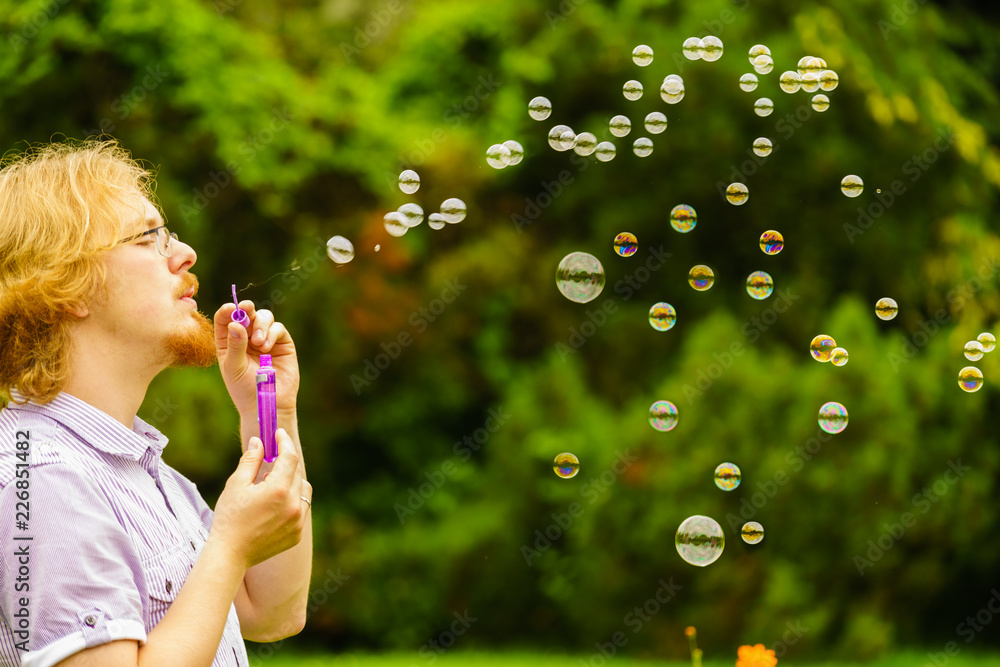 Man blowing soap bubbles outdoor