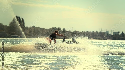 Sportsman swirling on speedy jet ski at sunset in slow motion. Extreme water sport. Jet ski rider enjoy water waves photo