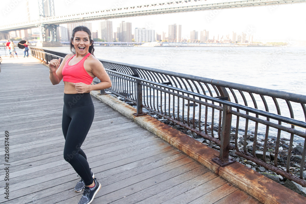 Happy woman running in place during outdoor workout