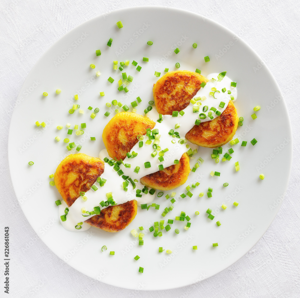 potato patties with sour cream decorated with green onion potato patties with sour cream decorated with green onion