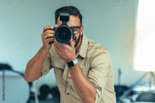Portrait of a photographer taking photo standing in a studio photo