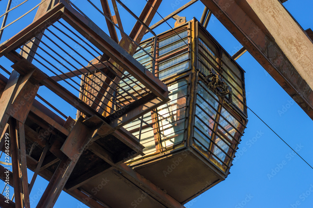 Fototapeta premium gantry crane, telpher, old, ancient, past, broken, abandoned, rusty, closed production, work; orange; metal; environment; vintage; old; ancient; past; broken; abandoned; rusty; closed production