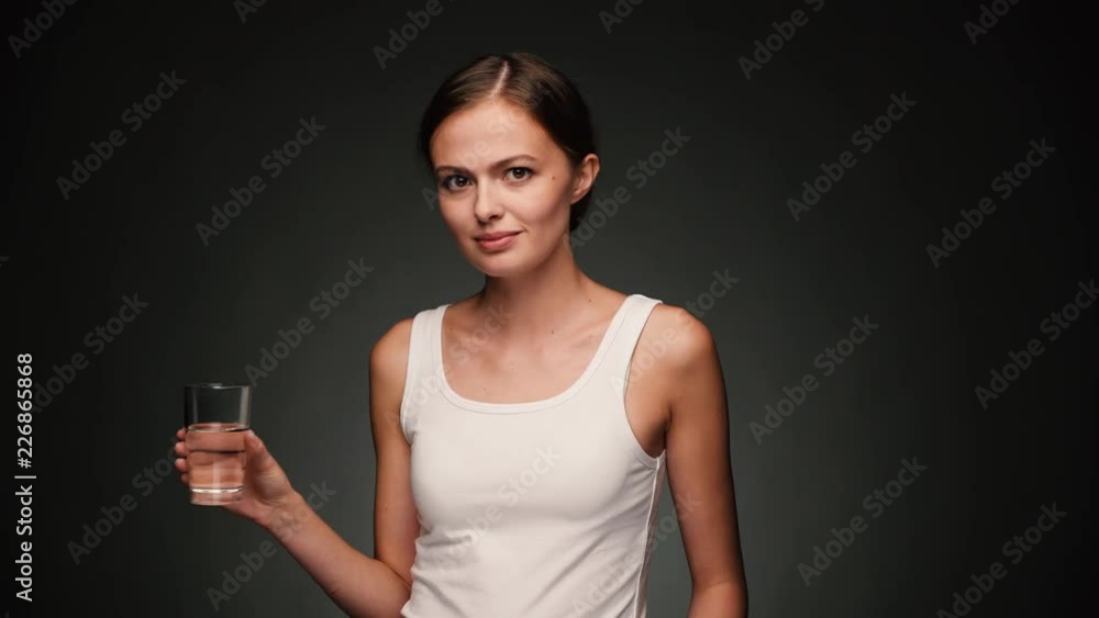 Attractive woman in white shirt drinking water Attractive woman in white shirt drinking water