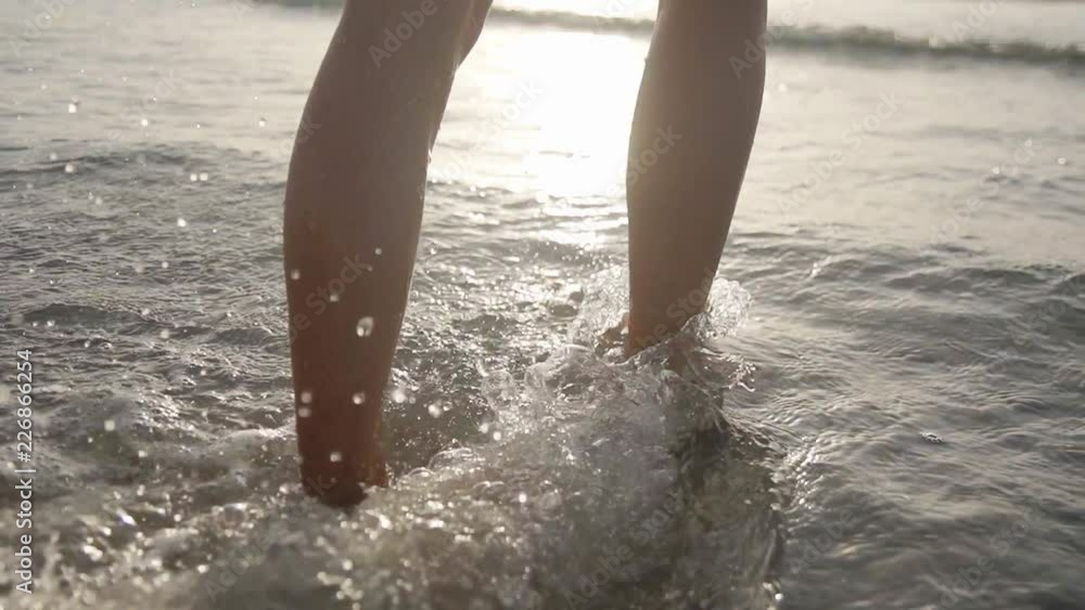 Girl feet and legs walking on water waves Slim female legs move on seafront Splash of water Holiday on beach in slow motion Perfect woman legs joyfully running on seashore Enjoy summer vacation Girl feet and legs walking on water waves Slim female legs move on seafront Splash of water Holiday on beach in slow motion Perfect woman legs joyfully running on seashore Enjoy summer vacation