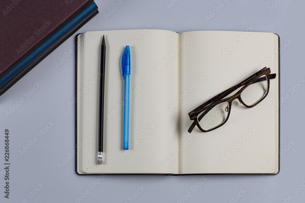 An empty outdoor diary with a pen and pencil and glasses An empty outdoor diary with a pen and pencil and glasses