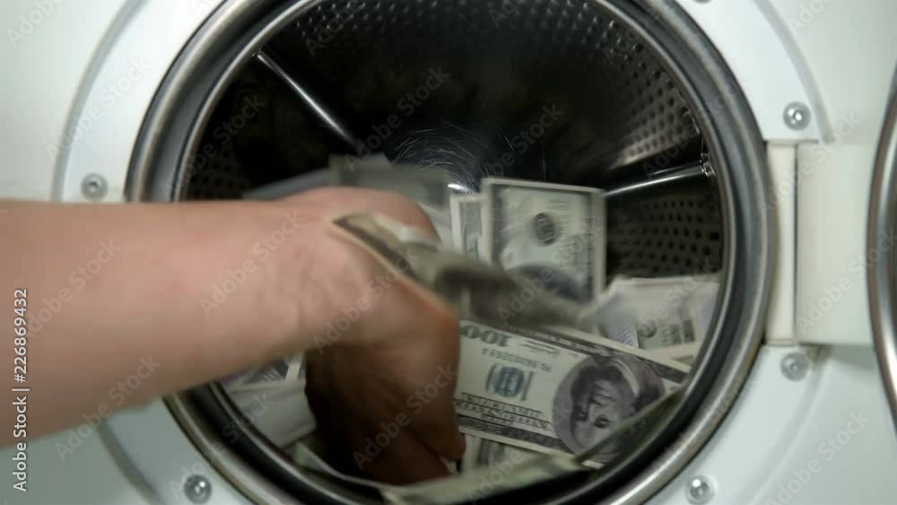 man puts money in the washing machine, dollars and euros, closeup man puts money in the washing machine, dollars and euros, closeup