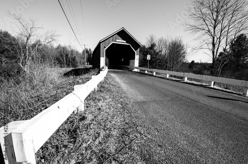 The Carlton Covered Bridge in Swanzey New Hampshire crosses the Ashuelot River. Black and white photo