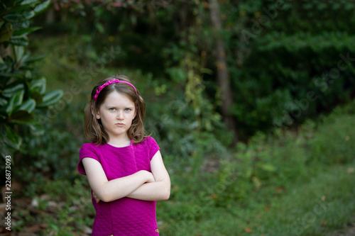 Canvas Print Sullen Little Girl With Attitude Outside with Arms Crossed