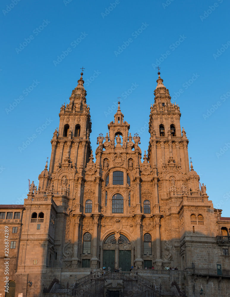 Facade of historic Santiago de Compostela cathedral in Spain at sunset.