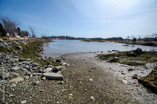 Rocky, scenic saltwater shoreline along the Atlantic Ocean at the Goat Island Saltwater Fishing Access area near Portsmouth, New Hampshire in the springtime.  photo