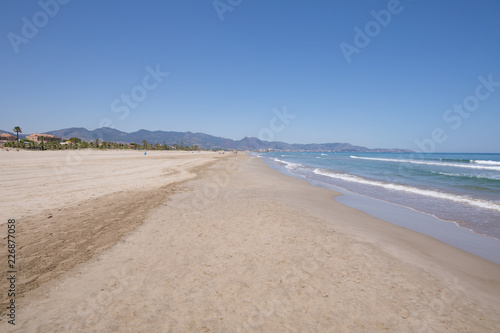 landscape beach of Grao of Castellon named PIne or Pinar, in Valencia, Spain, Europe, from sea shore. Blue clear sky, Mediterranean Sea and Benicassim in the horizon