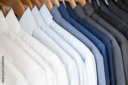 Valokuvatapetti Office Business shirts hanging in a closet ordered by colour