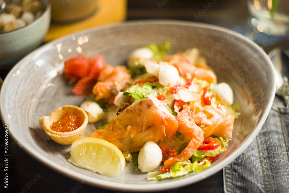 salad with salmon, caviar, vegetables, herbs and lemon share, salad with fish and vegetables