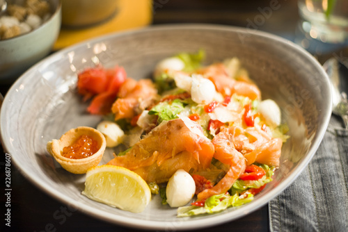 salad with salmon, caviar, vegetables, herbs and lemon share, salad with fish and vegetables