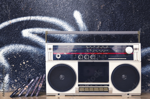 Vintage boombox radio with cassettes on a graffiti background
