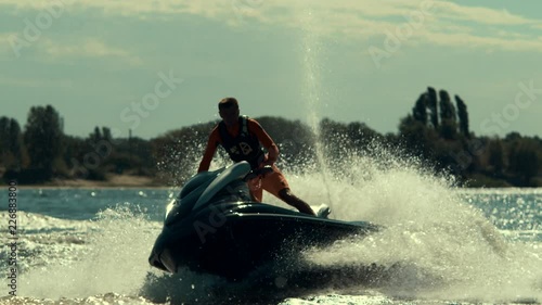 Sportsman riding extreme jet ski on river. Rider drive jet ski in slow motion. Summer extreme lifestyle. photo
