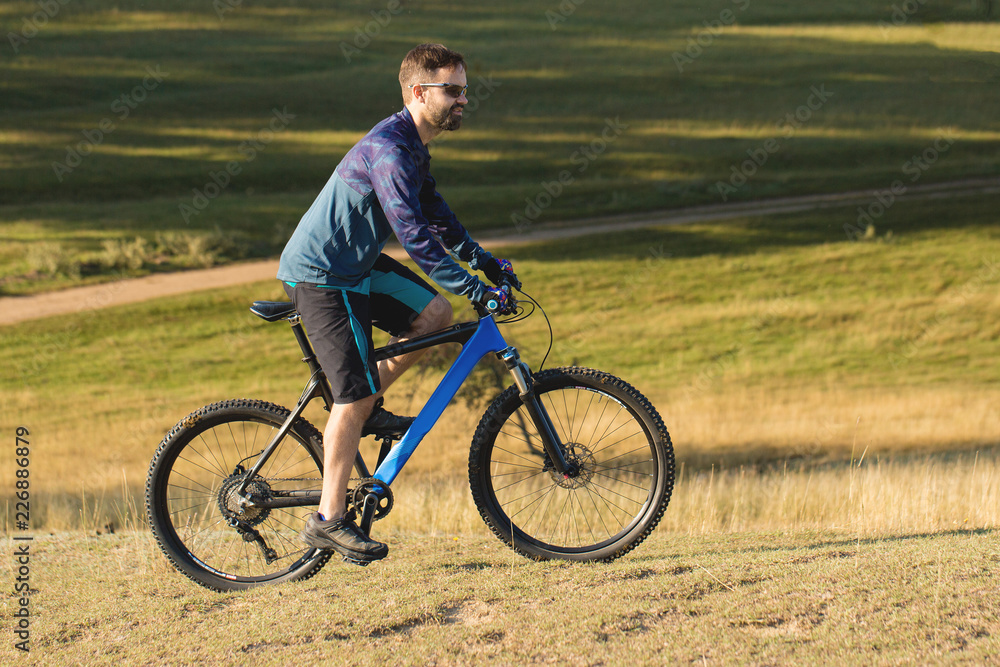 Cyclist in shorts and jersey on a modern carbon hardtail bike with an air suspension fork	