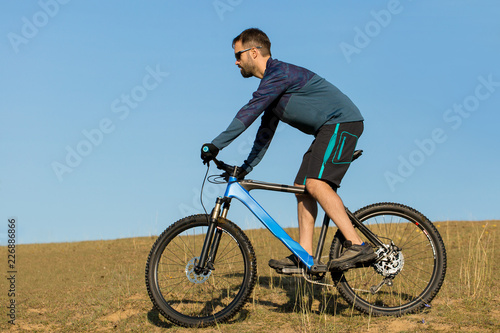 Cyclist in shorts and jersey on a modern carbon hardtail bike with an air suspension fork	