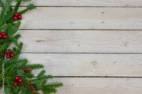Holiday border with greenery along the left side with copy space